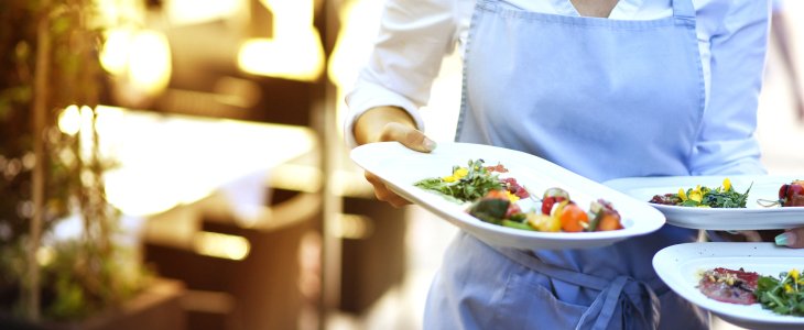 A server carrying plates of food