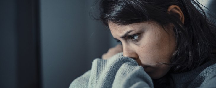 A woman covering her face and looking sad