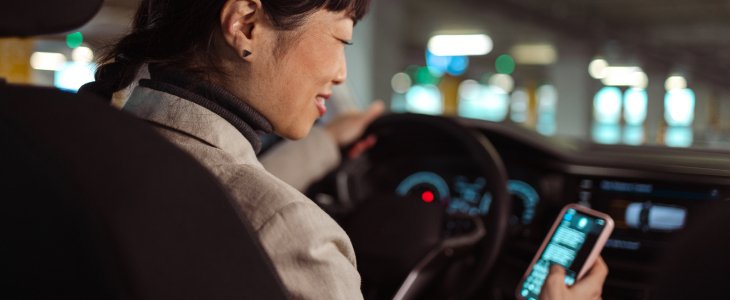A woman looking at her phone while driving